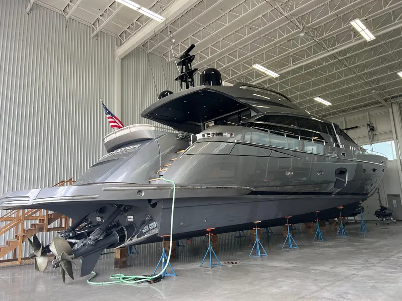 Slide: The Image of 2017 Pershing 92 Motor Yacht in a warehouse, elevated on stands. - 11