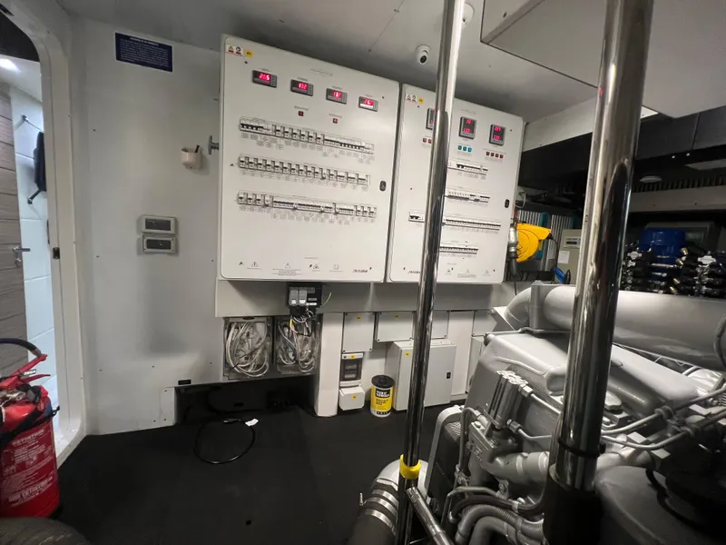 Slide: The Image of Engine room of a 2017 Pershing 92 Motor Yacht with control panels and machinery. - 17