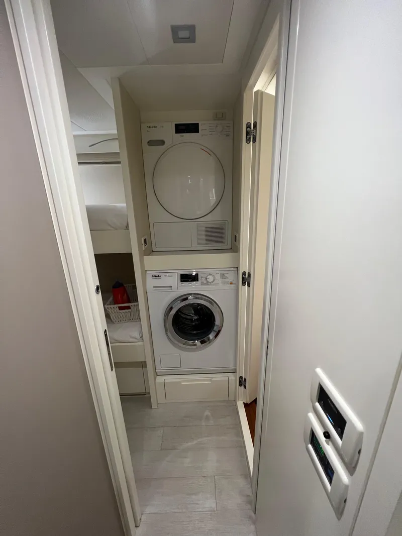 Slide: The Image of Laundry area in 2017 Pershing 92 Motor Yacht with stacked washer and dryer. - 21