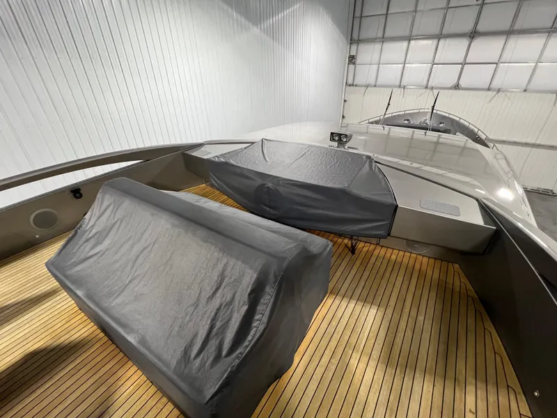 Slide: The Image of 2017 Pershing 92 Motor Yacht deck with covered seating and wooden flooring. - 26