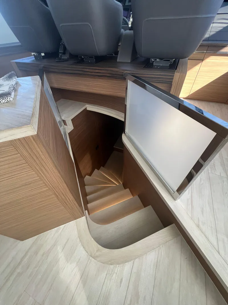 Slide: The Image of Staircase leading below deck on 2017 Pershing 92 Motor Yacht, featuring modern wood finish. - 38