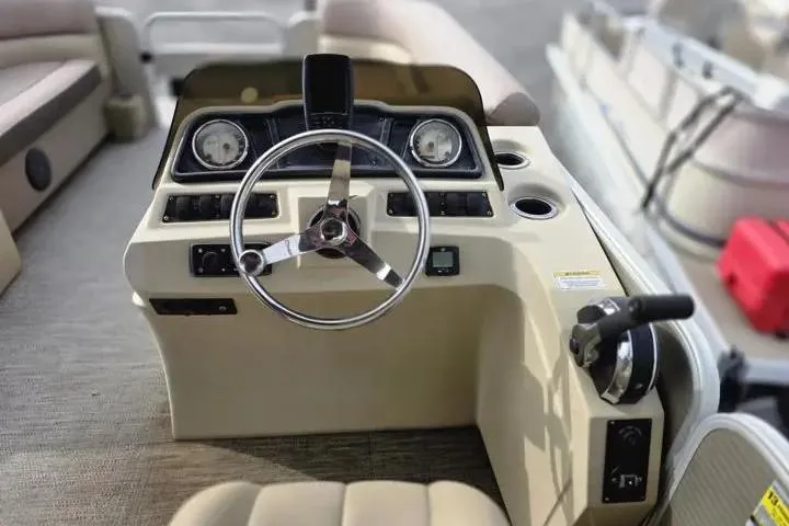 Slide: The Image of 2021 Godfrey Sweetwater 2086 BF boat dashboard with steering wheel and controls. - 13
