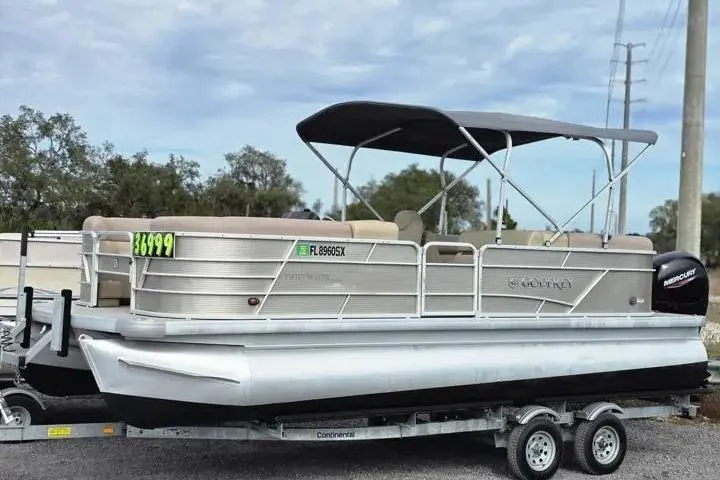 The Image of 2021 Godfrey Sweetwater 2086 BF pontoon boat on trailer, featuring canopy and outboard motor. - 2