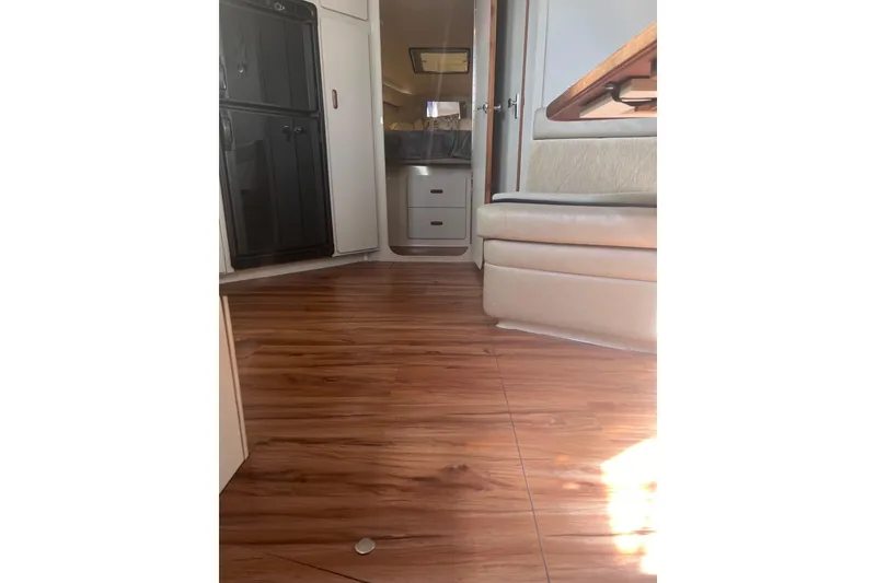 Slide: The Image of Interior of 1990 Carver 528 Montego with wood flooring and beige seating. - 11