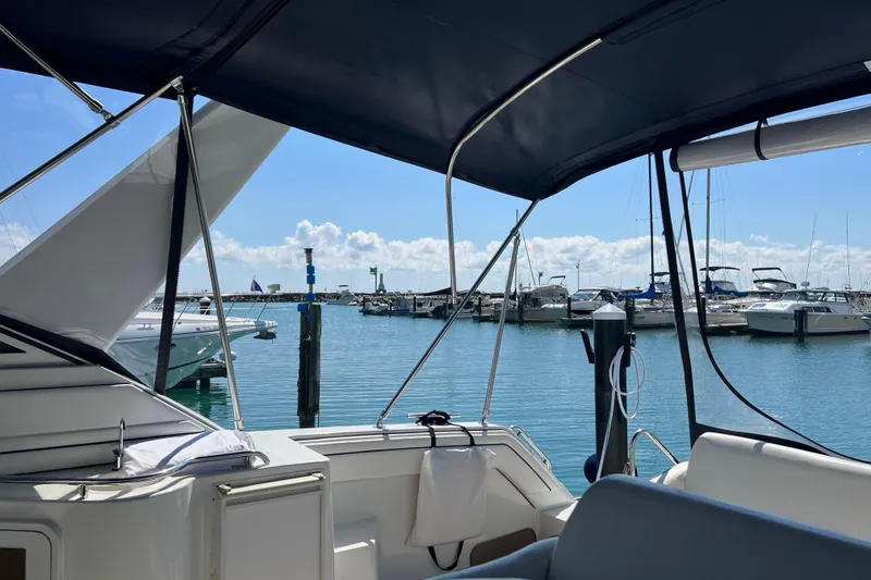 Slide: The Image of 1990 Carver 528 Montego yacht docked at a sunny marina with clear blue skies. - 8