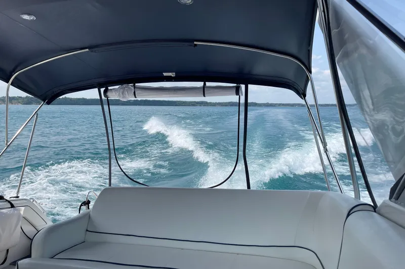 Slide: The Image of 1990 Carver 528 Montego boat cruising on a clear blue lake. - 9