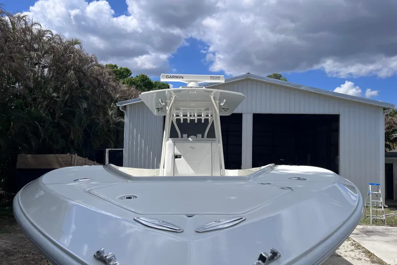 Slide: The Image of 2021 SeaVee 340B Open boat in front of a metal garage under cloudy sky. - 11