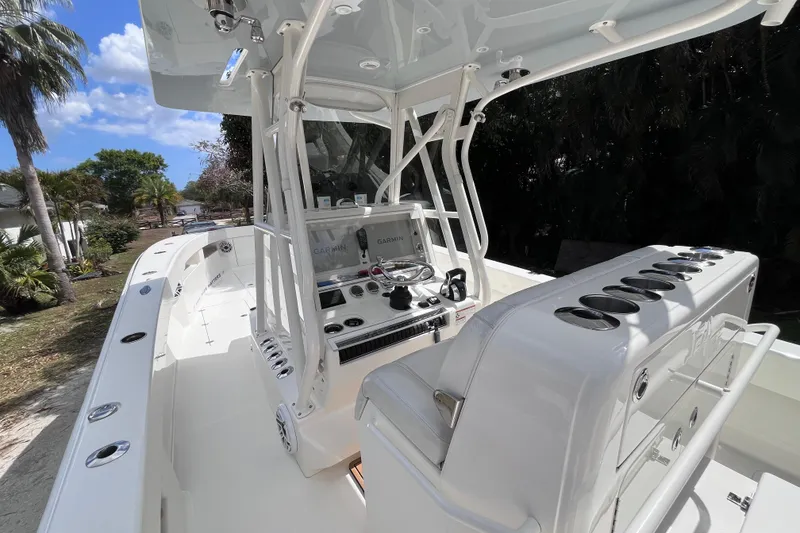 Slide: The Image of 2021 SeaVee 340B Open boat interior with helm, seating, and rod holders under a clear sky. - 20