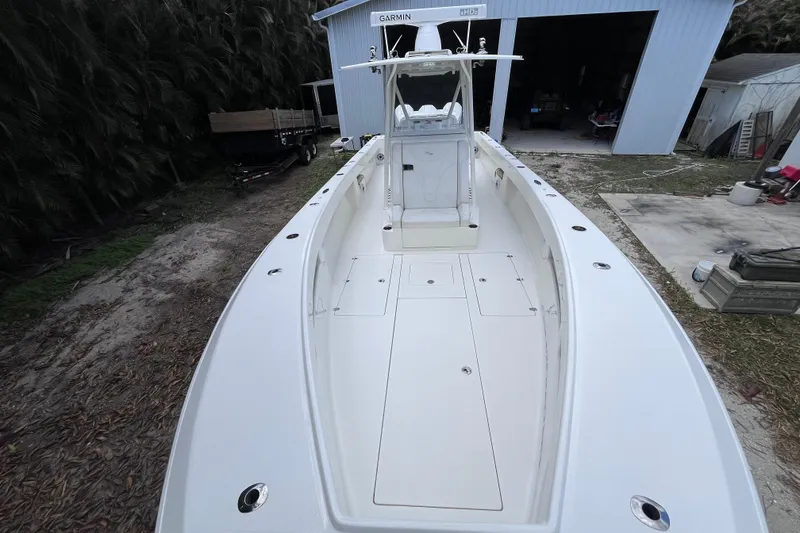 Slide: The Image of 2021 SeaVee 340B Open boat, white deck, parked near a blue garage. - 27