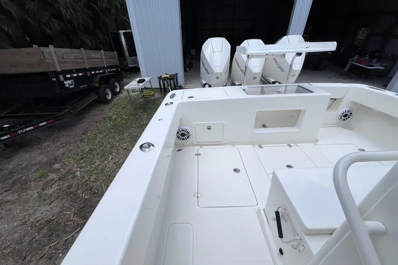 Slide: The Image of 2021 SeaVee 340B Open boat with triple Mercury engines, docked near a trailer. - 33