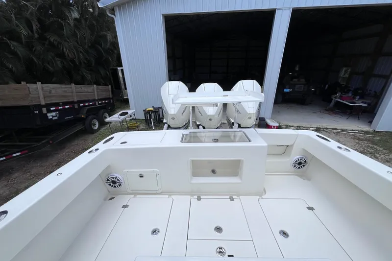 Slide: The Image of 2021 SeaVee 340B Open boat with triple engines, docked near a storage building. - 34