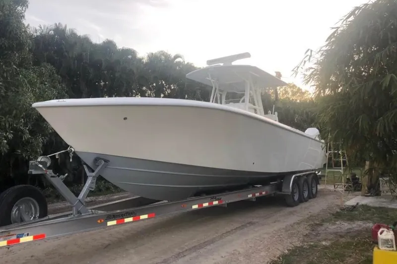 Slide: The Image of 2021 SeaVee 340B Open boat on trailer, surrounded by trees. - 4