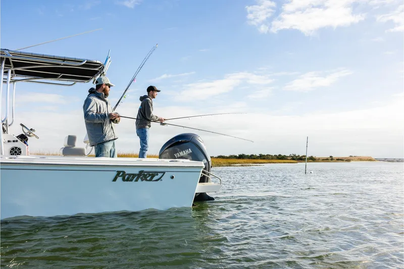Slide: The Image of Two people fishing on a 2026 Parker 210 Coastal boat in open water. - 4