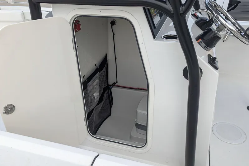 Slide: The Image of 2026 Parker 210 Coastal boat interior with open storage compartment and steering console. - 8