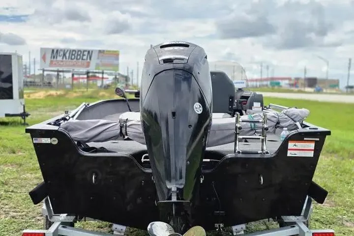 Slide: The Image of 2021 Lowe Fishing Machine 1775SC boat with outboard motor, parked on grass. - 21