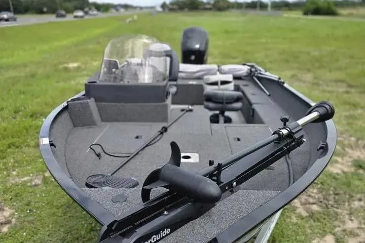 Slide: The Image of 2021 Lowe Fishing Machine 1775SC boat on grassy area, featuring trolling motor and seating. - 29