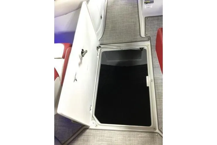 Slide: The Image of 2024 Crownline Eclipse E235 boat storage compartment with open hatch, featuring red and white interior. - 8