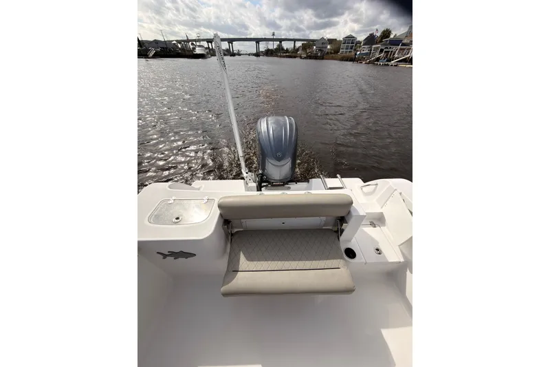 Slide: The Image of 2022 Sportsman Open 242 Center Console boat on a calm river with bridge view. - 12