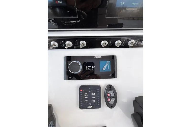 Slide: The Image of Control panel of 2022 Sportsman Open 242 Center Console boat with Fusion audio system. - 16