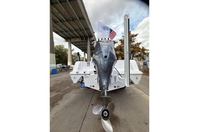 Slide: The Image of 2022 Sportsman Open 242 Center Console boat with powerful outboard motor under a bridge. - 6