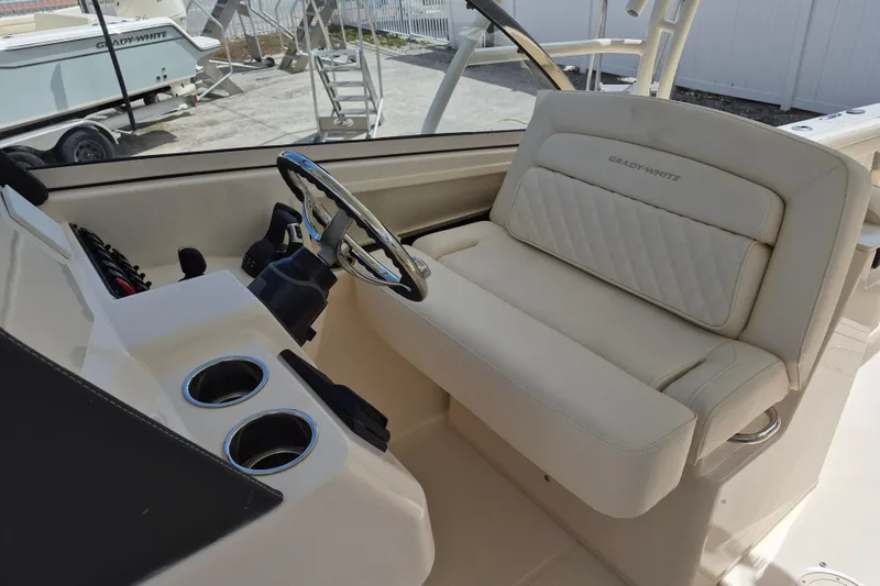 Slide: The Image of 2026 Grady-White Freedom 285 boat interior with steering wheel and cushioned seating. - 13
