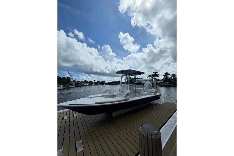 Slide: The Image of 2024 Billfish 24 boat docked under a cloudy sky, surrounded by water and palm trees. - 3