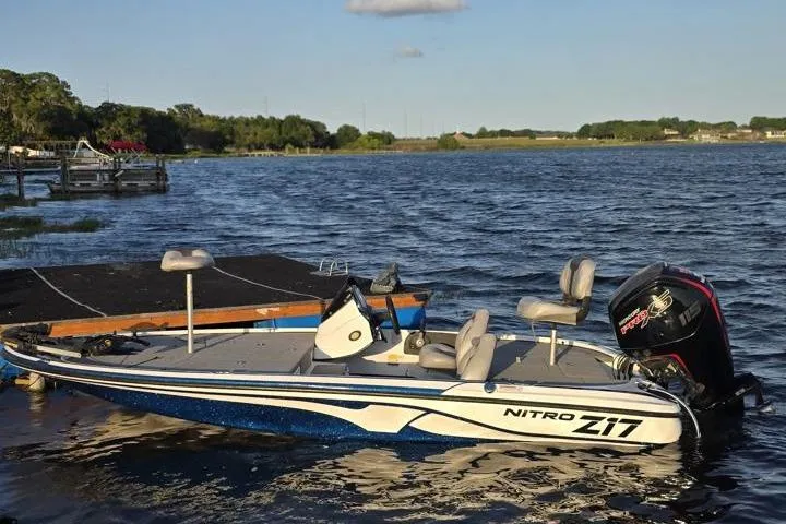 Slide: The Image of 2017 Nitro Z17 boat docked on a serene lake with lush greenery. - 21