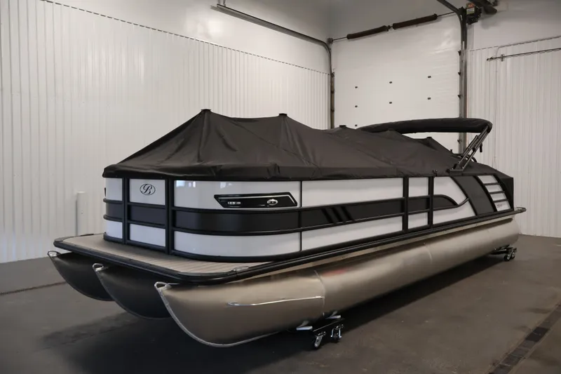 Slide: The Image of 2026 Bentley Pontoons 253 Swingback Dual Captain Elite Tri-Toon in a showroom, covered and sleek. - 37
