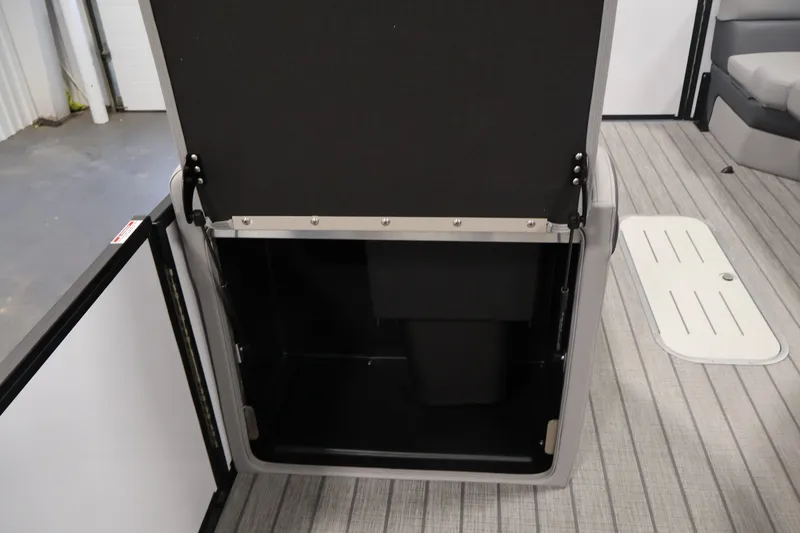 Slide: The Image of 2026 Bentley Pontoons 253 Swingback storage compartment, open on a sleek, modern boat interior. - 31