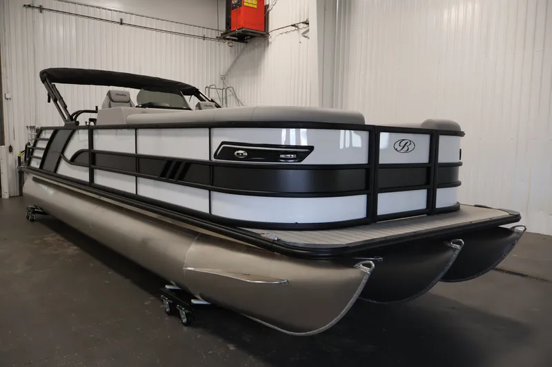 Slide: The Image of 2026 Bentley Pontoons 253 Swingback Dual Captain Elite Tri-Toon in a showroom setting. - 2
