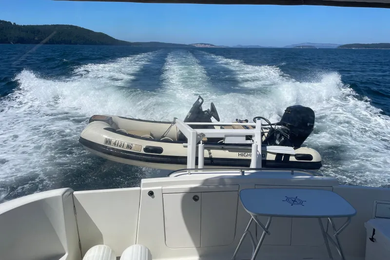 Slide: The Image of 2004 Meridian 411 Sedan cruising with inflatable boat on blue ocean waters. - 102