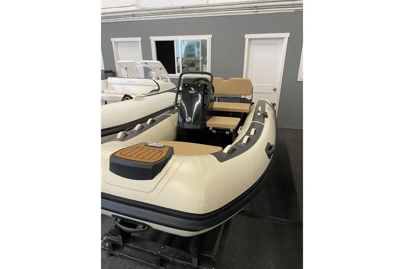 Slide: The Image of Inflatable boat with beige seating, displayed indoors, near a 2004 Meridian 411 Sedan. - 105