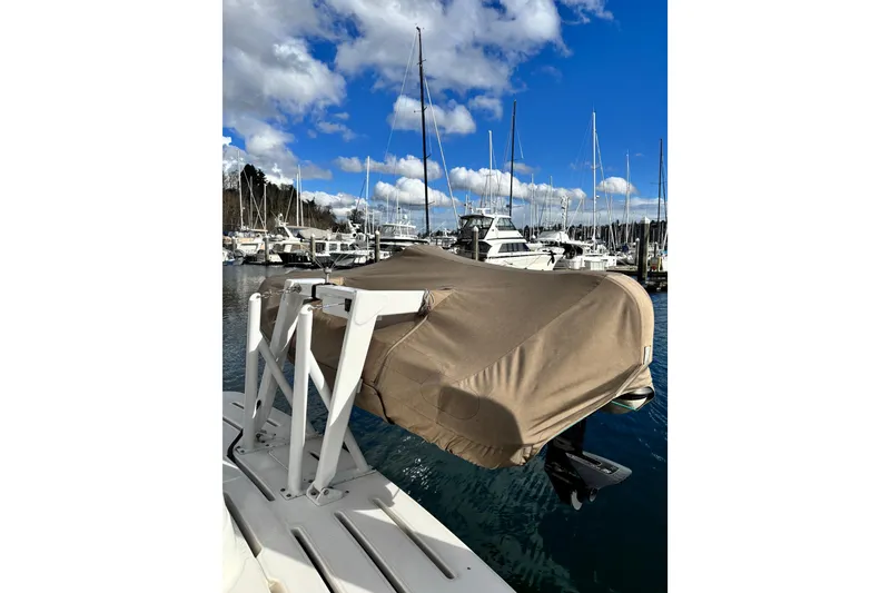 Slide: The Image of Covered boat on a dock, surrounded by sailboats, under a blue sky. Meridian 411 Sedan, 2004. - 106