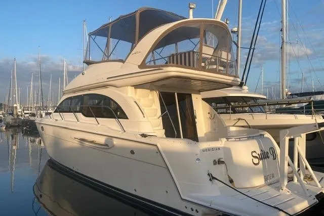 Slide: The Image of 2004 Meridian 411 Sedan yacht docked at marina, showcasing elegant design and spacious upper deck. - 108