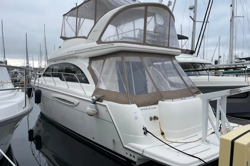 Slide: The Image of 2004 Meridian 411 Sedan yacht docked at marina, featuring sleek design and spacious upper deck. - 109