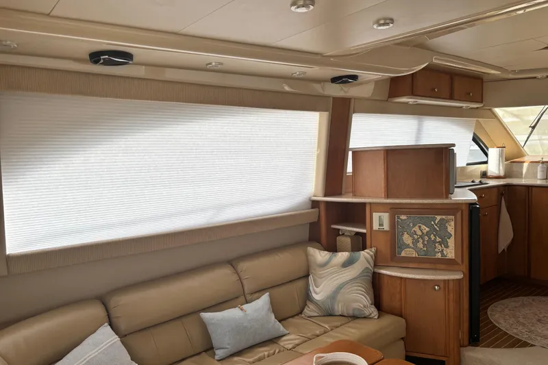 Slide: The Image of Interior of 2004 Meridian 411 Sedan yacht with beige leather seating and wooden cabinetry. - 11