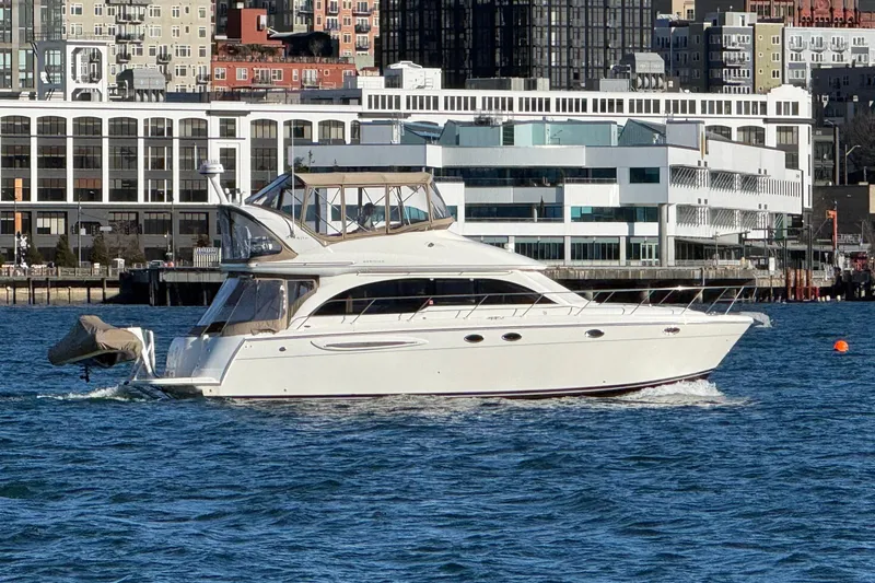 Slide: The Image of 2004 Meridian 411 Sedan yacht cruising near urban waterfront buildings. - 2