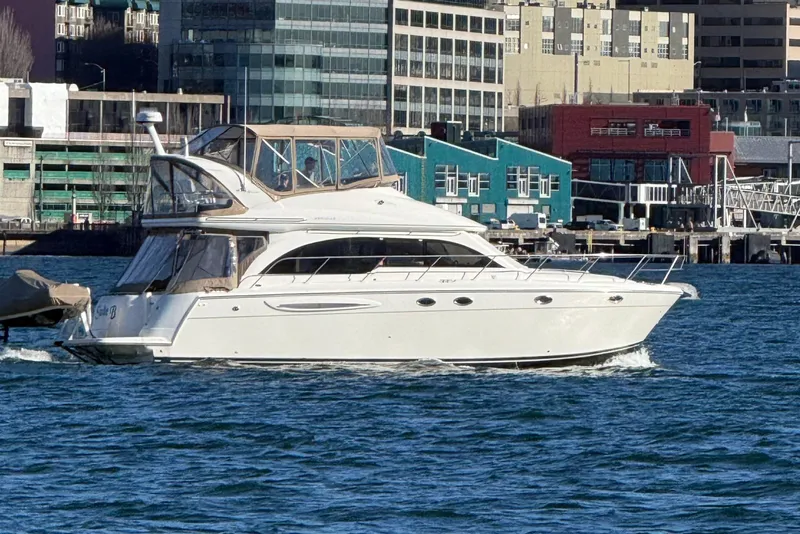 Slide: The Image of 2004 Meridian 411 Sedan yacht cruising near urban waterfront buildings. - 3