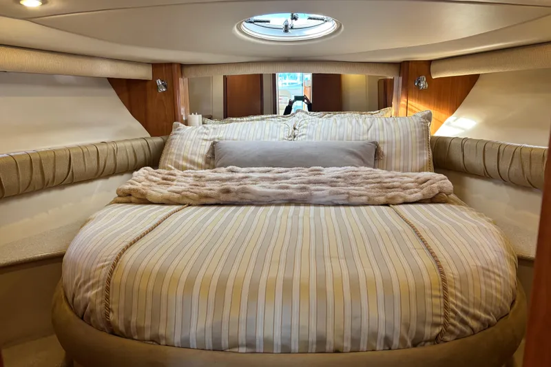 Slide: The Image of Luxurious bedroom interior of 2004 Meridian 411 Sedan yacht with plush bedding and porthole. - 45