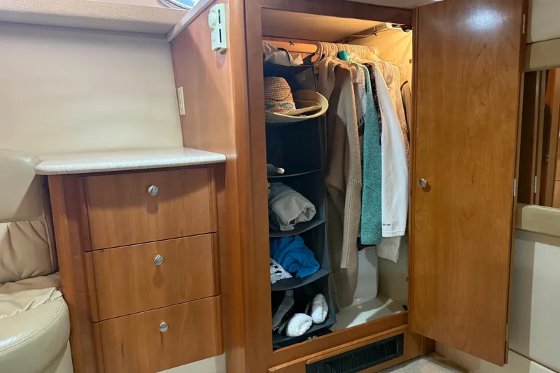 Slide: The Image of Wooden closet with clothes and accessories inside a 2004 Meridian 411 Sedan yacht. - 64