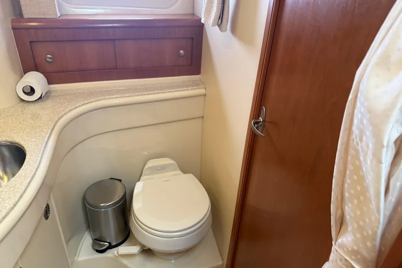 Slide: The Image of Bathroom interior of 2004 Meridian 411 Sedan yacht, featuring toilet and wooden cabinetry. - 75