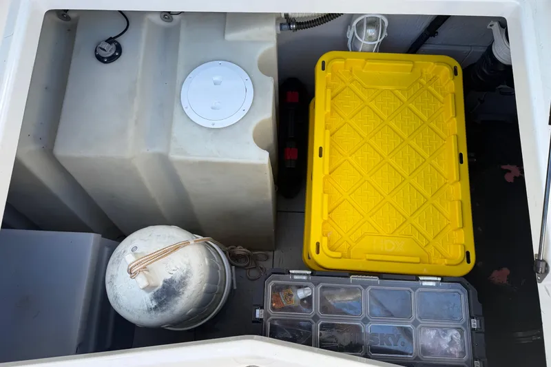 Slide: The Image of Storage compartment of a 2004 Meridian 411 Sedan with yellow container and equipment. - 99