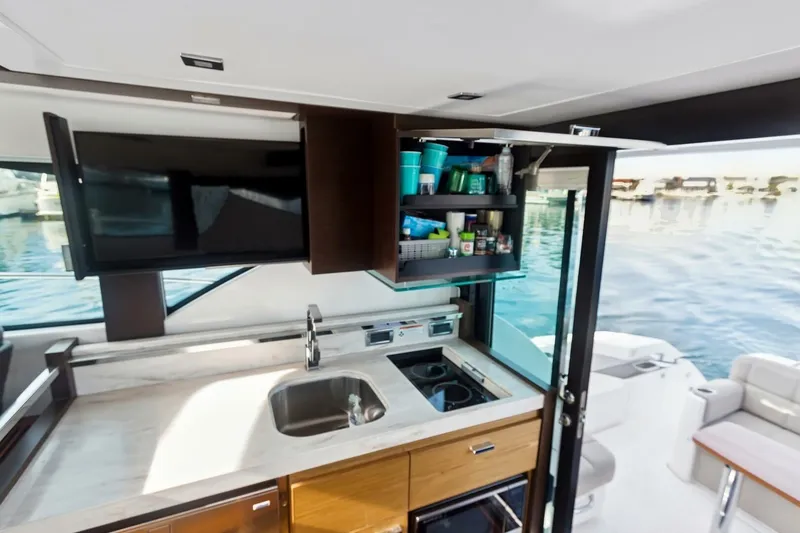Slide: The Image of Modern kitchen area on 2017 Tiara Yachts C39 Coupe with open cabinet and sink. - 15