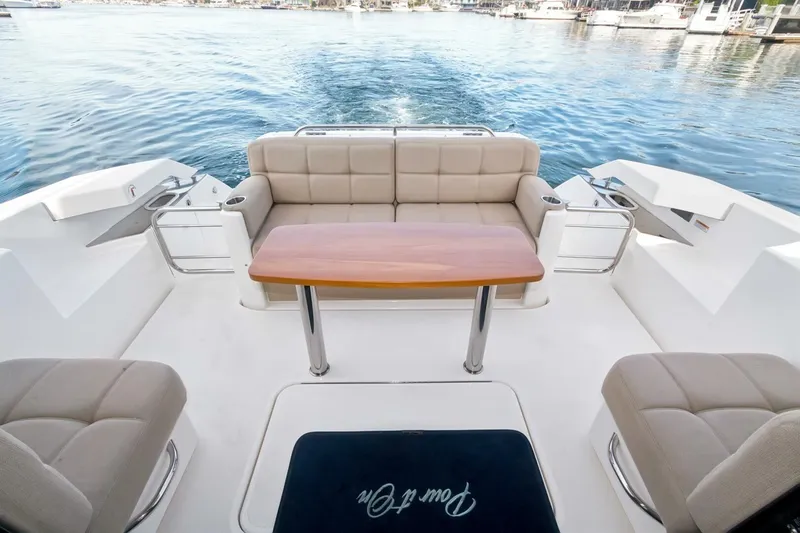 Slide: The Image of 2017 Tiara Yachts C39 Coupe cockpit with seating and table, overlooking serene water. - 21