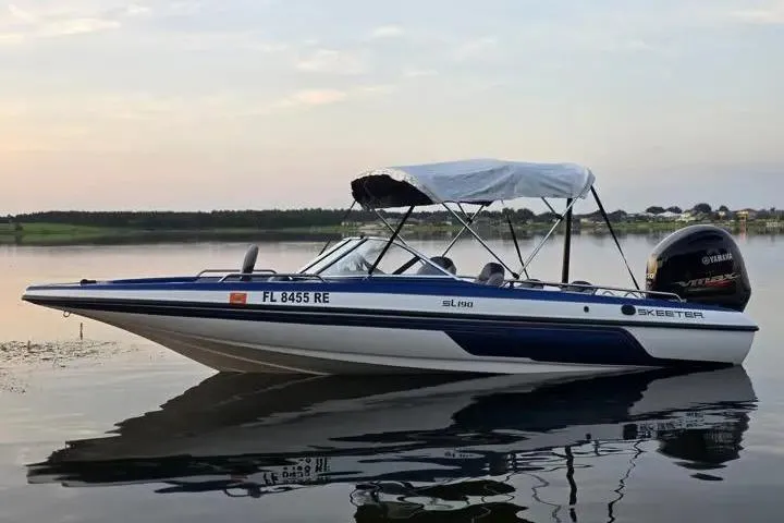 Slide: The Image of 2017 Skeeter SL 190 boat with canopy on calm lake at sunset. - 21