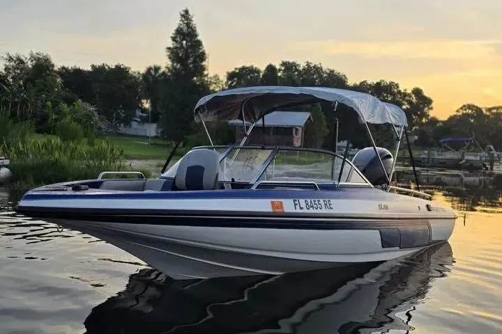 Slide: The Image of 2017 Skeeter SL 190 boat on calm water at sunset, featuring a sleek design and canopy. - 22