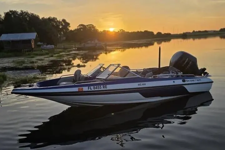 Slide: The Image of 2017 Skeeter SL 190 boat on calm lake at sunset, reflecting serene landscape. - 26