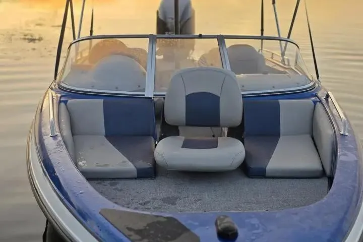 Slide: The Image of 2017 Skeeter SL 190 boat interior with blue and gray seating on calm water. - 29