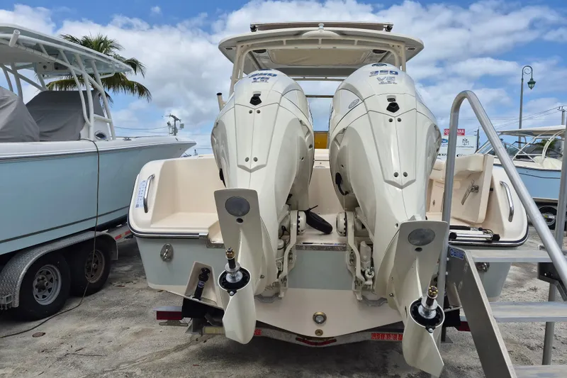 Slide: The Image of 2026 Grady-White Freedom 285 boat with dual outboard engines, docked under a blue sky. - 24