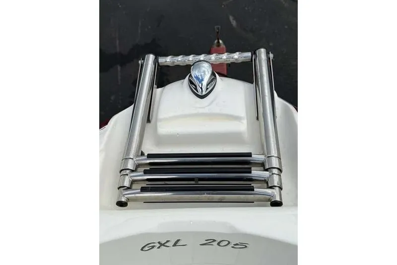 Slide: The Image of 2007 Glastron GXL 205 boat ladder and emblem on white surface. - 1